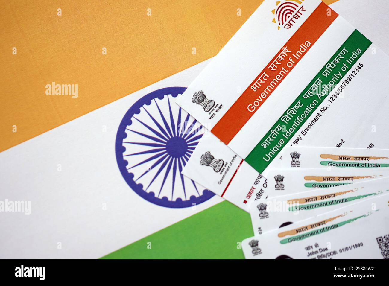 Indische Aadhaar-Karte von der Unique Identification Authority of India auf indischer Flagge Nahaufnahme Stockfoto