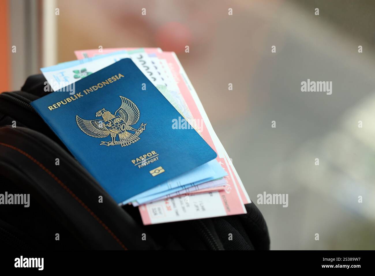 Blue Republic Indonesien Pass mit Geld und Flugtickets auf touristischen Rucksack Nahaufnahme. Tourismus und Reisekonzept. Blaue Republik Indonesien Stockfoto