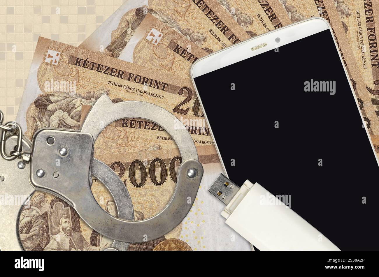 2000 ungarische Forint-Rechnungen und Smartphone mit Polizeihandschellen. Konzept von Hackern Phishing-Angriffen, illegalem Betrug oder Online-Spyware Soft Stockfoto