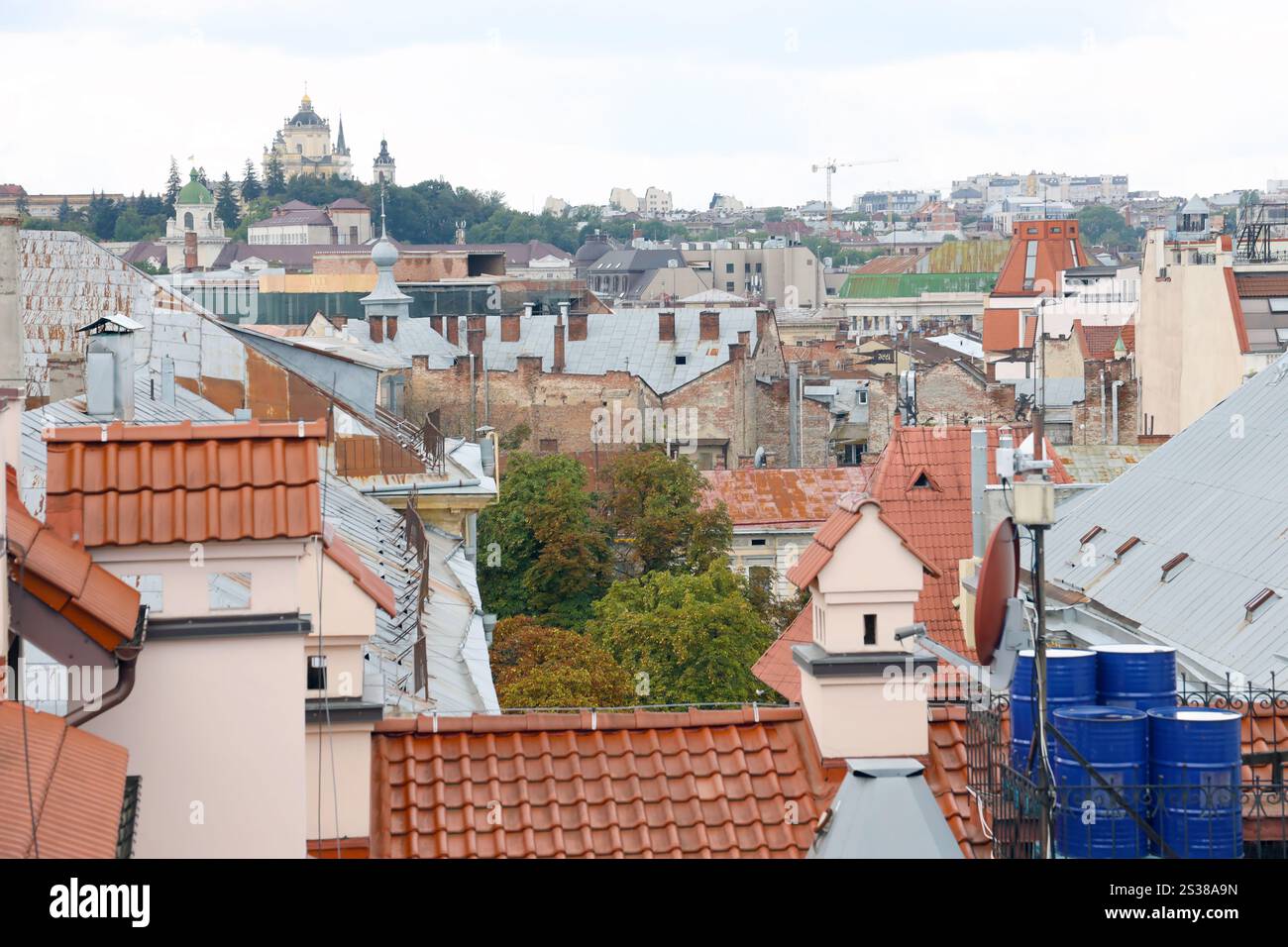 Blick auf die Dächer der historischen Altstadt von Lemberg in der Ukraine. Kirchtürme und viele rostige Schindeldächer im Hintergrund. Blick auf die Dächer von Stockfoto