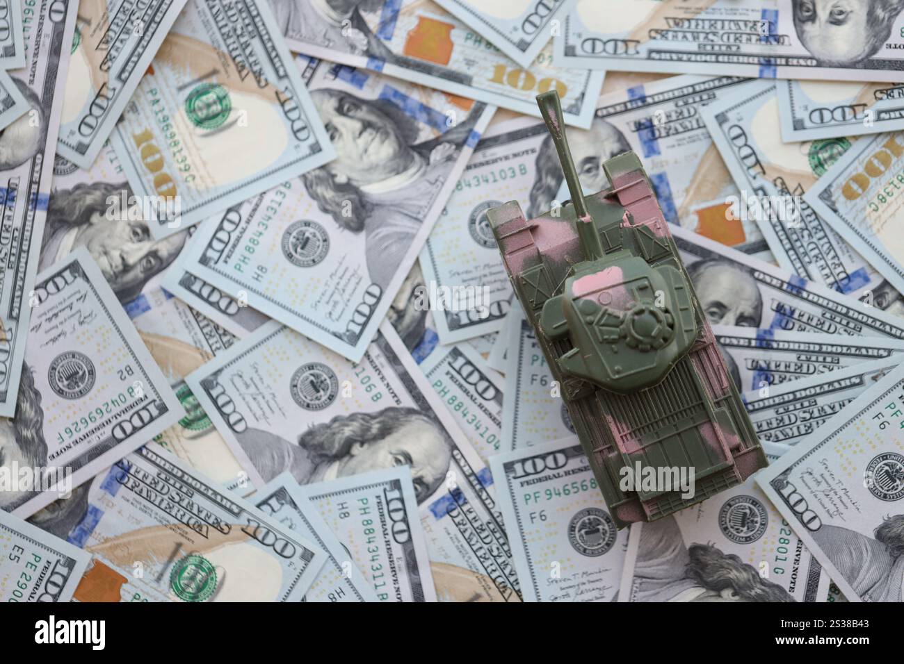 Spielzeugtank auf US-Dollar-Banknoten aus nächster Nähe. Das Konzept der Kriegskosten, der Militärausgaben und der Wirtschaftskrise. Spielzeugtank auf US Hundred Stockfoto