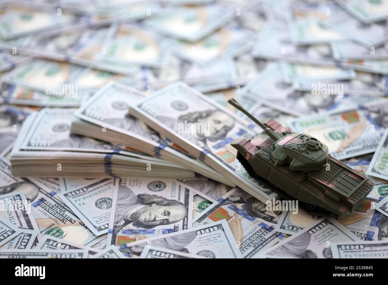 Spielzeugtank auf US-Dollar-Banknoten aus nächster Nähe. Das Konzept der Kriegskosten, der Militärausgaben und der Wirtschaftskrise. Spielzeugtank auf US Hundred Stockfoto