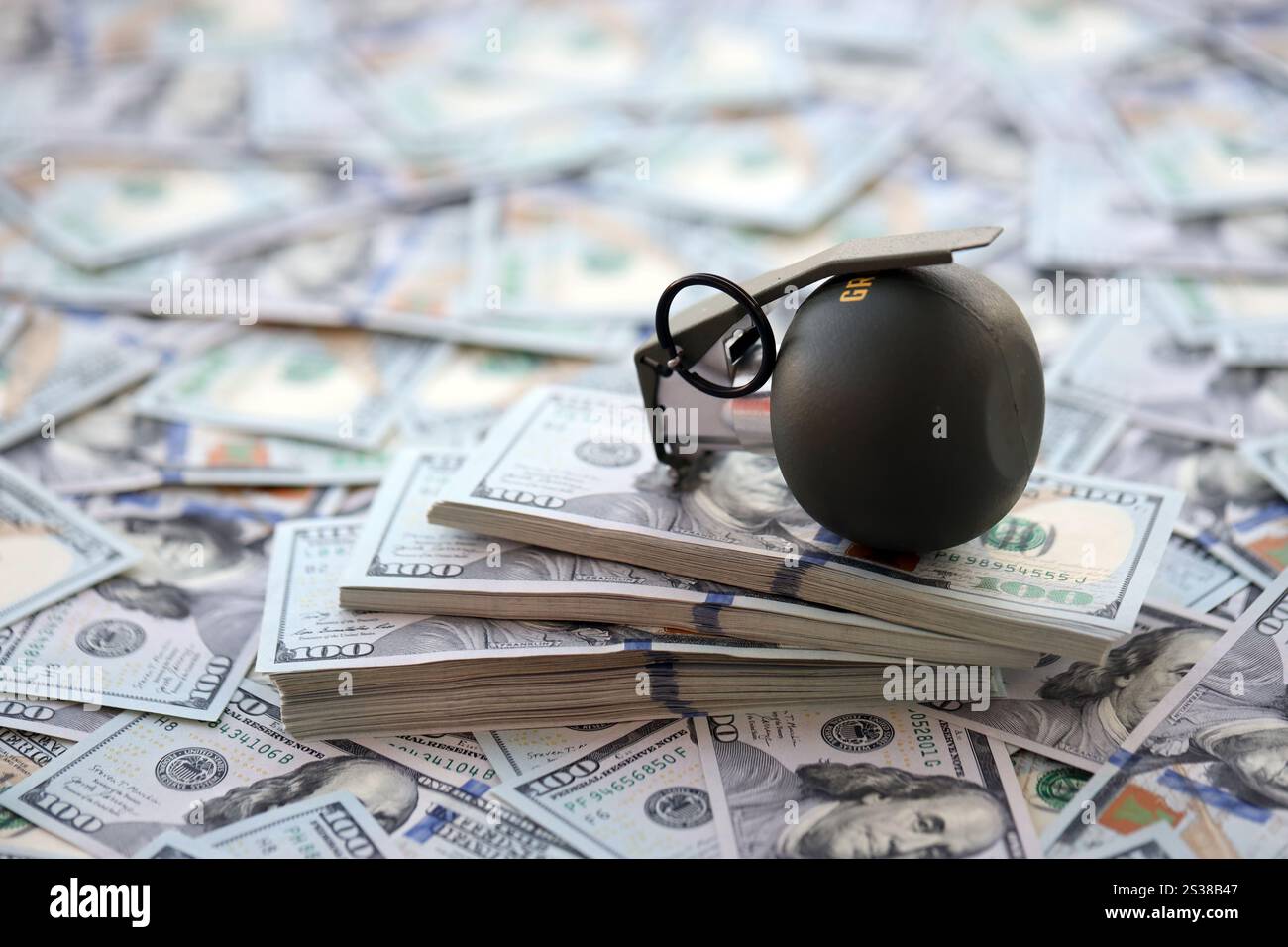 Granate mit einem Scheck vor dem Hintergrund einer riesigen Menge amerikanischer Dollarscheine aus der Nähe. Granate mit einem Scheck vor dem Hintergrund von Riesen Stockfoto