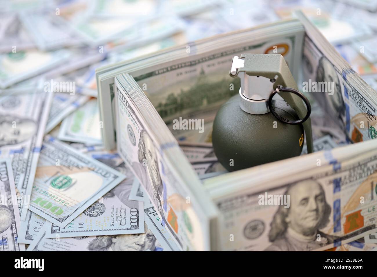 Granate mit einem Scheck vor dem Hintergrund einer riesigen Menge amerikanischer Dollarscheine aus der Nähe. Granate mit einem Scheck vor dem Hintergrund von Riesen Stockfoto