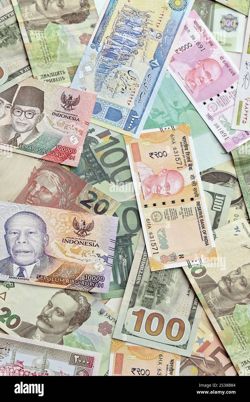 Viele Banknoten unterschiedlicher Währung. Hintergrund großer Mengen zufälliger Geldrechnungen aus nächster Nähe. Viele Banknoten unterschiedlicher Währung. Hintergrund von Stockfoto