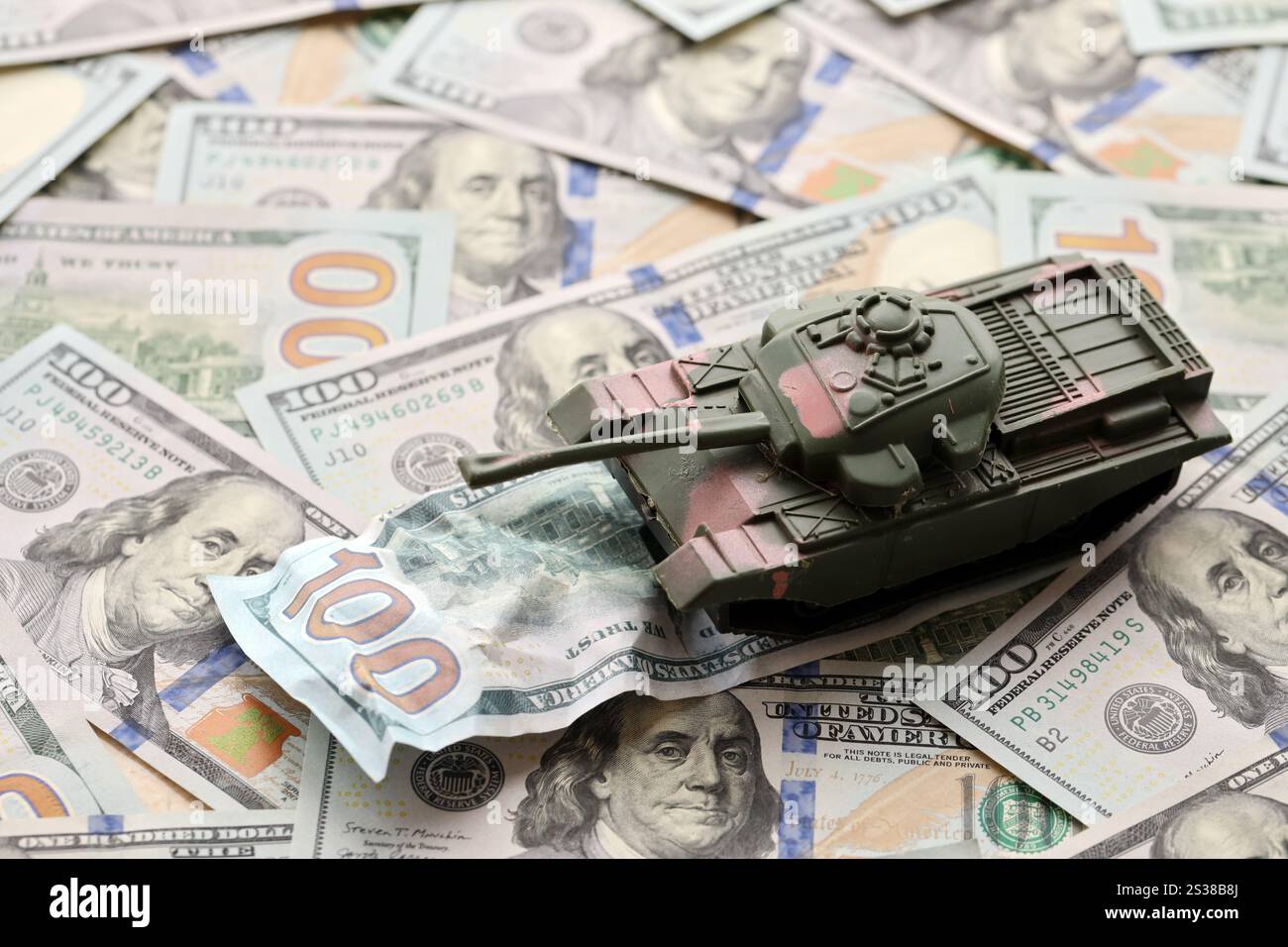 Tank auf zerknitterten 100-Dollar-Banknoten. Hintergrund der Kriegsfinanzierung und des militärischen Unterstützungspreises für die Vereinigten Staaten von Amerika. Tank auf zerknittert Stockfoto