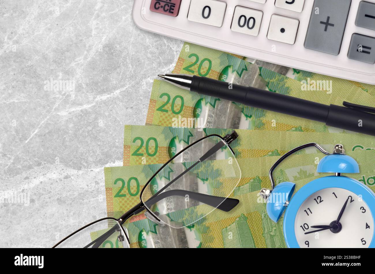 20 kanadische Dollarscheine und Taschenrechner mit Brille und Stift. Geschäftsdarlehen oder Steuerzahlung Saisonkonzept. Finanzplanung und Zeit für die Zahlung von Steuern. Stockfoto