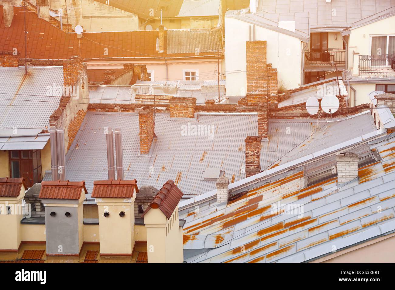 Blick auf die Dächer der historischen Altstadt von Lemberg in der Ukraine. Kirchtürme und viele rostige Schindeldächer im Hintergrund. Blick auf die Dächer von Stockfoto