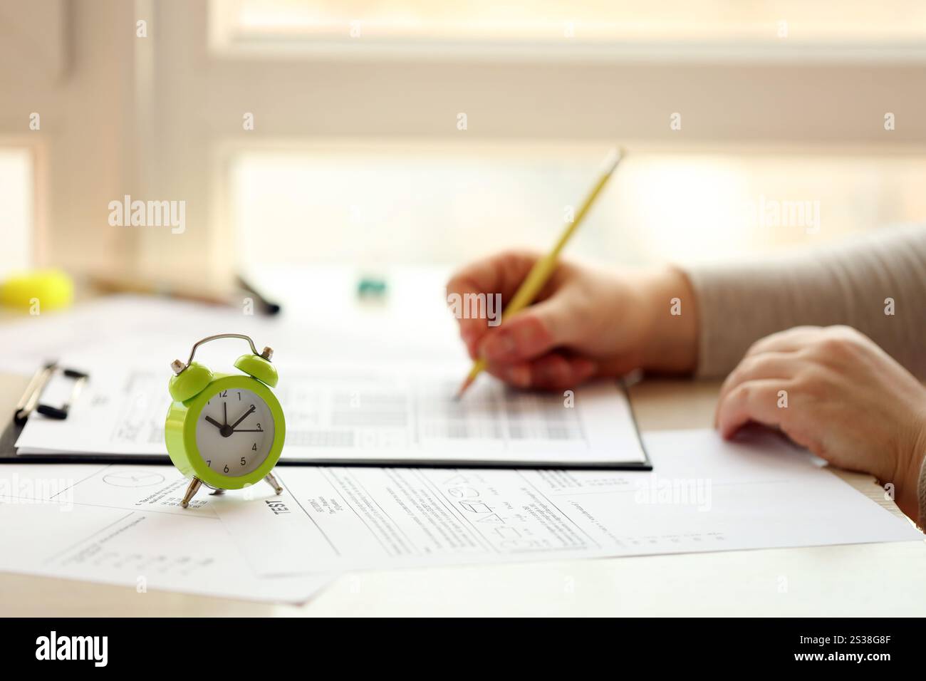 Weibliche Schülerhände testen in Übung und nehmen Ausfüllen von Prüfungsbogen mit Bleistift im Schulprüfungsraum, Bildungskonzept. Weibliche Studentenhände Stockfoto