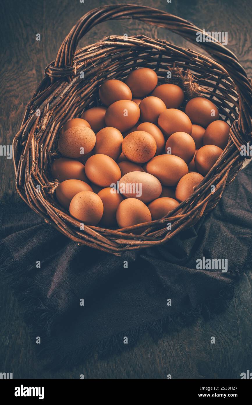 Braune Bio-Eier in einem Korb auf Holztisch Stockfoto