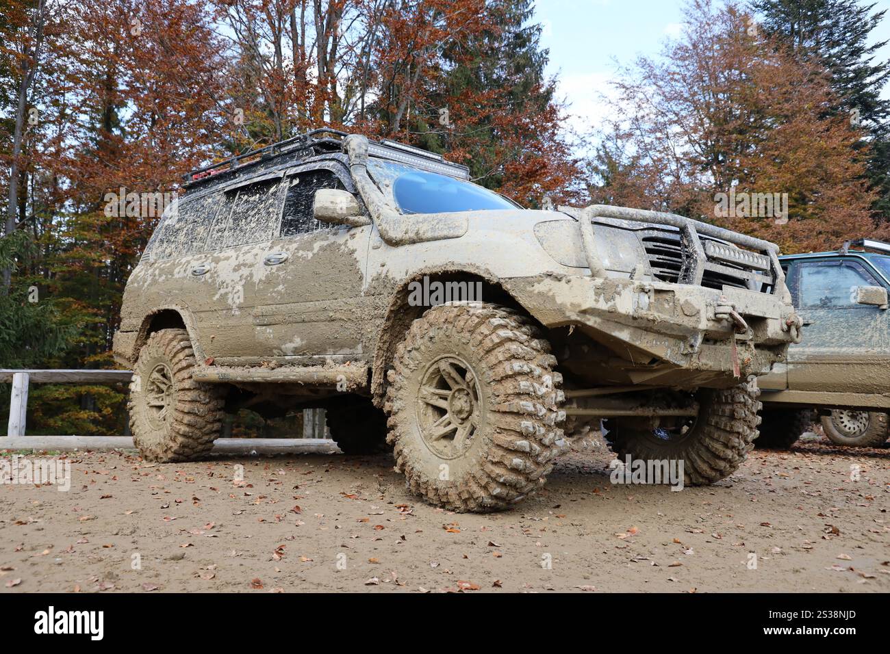 Auto in einer Landschaft mit Schlammweg. Geländewagen mit Geländewagen und Karosserie nach der Fahrt auf schlammigen Straßen. Auto in A Stockfoto