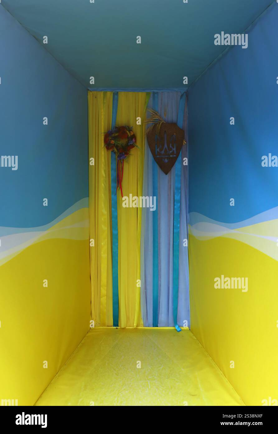 Ukrainische Fotozone in Gelb und Blau mit Bändern und Blumen aus nächster Nähe. Ukrainische Fotozone in Gelb und Blau mit Bändern und Stockfoto