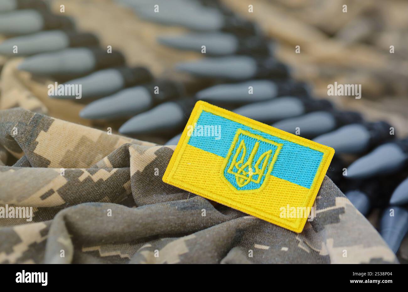 Ukrainisches Symbol und Maschinengewehrgürtel auf der Tarnuniform eines ukrainischen Soldaten. Der Begriff Krieg in der Ukraine, Patriotismus und Schutz Stockfoto