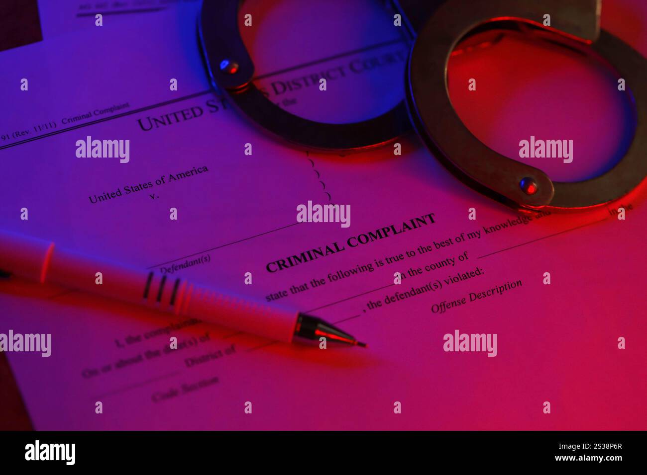 Bezirksgericht Strafanzeige Gerichtspapiere mit Handschellen und blauem Stift auf Tisch Nahaufnahme. Bezirksgericht Strafanzeige Gerichtspapiere mit Stockfoto