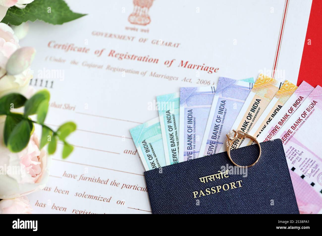 Indische Bescheinigung über die Registrierung der Ehe Blankodokument und Ehering mit Rupiah Geld auf Tisch Nahaufnahme. Indisches Zertifikat von Stockfoto
