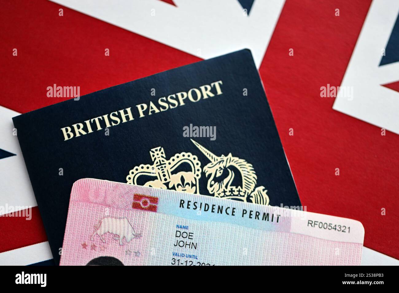 Aufenthaltserlaubnis BRP-Karte und britischer Pass des Vereinigten Königreichs auf der Flagge der Union Jack in Nahaufnahme. Aufenthaltserlaubnis BRP-Karte und britischer Reisepass von Stockfoto