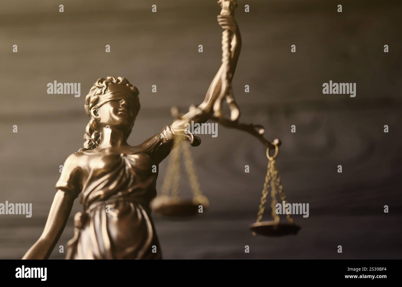 Die Statue der Gerechtigkeit - Lady Justice oder Justitia die römische Göttin der Gerechtigkeit. Statue auf schwarzer Holzwand. Das Konzept des Gerichtsverfahrens, Gerichtssaal Stockfoto
