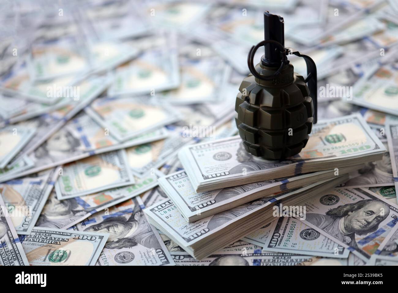 Granate mit einem Scheck vor dem Hintergrund einer riesigen Menge amerikanischer Dollarscheine aus der Nähe. Granate mit einem Scheck vor dem Hintergrund von Riesen Stockfoto