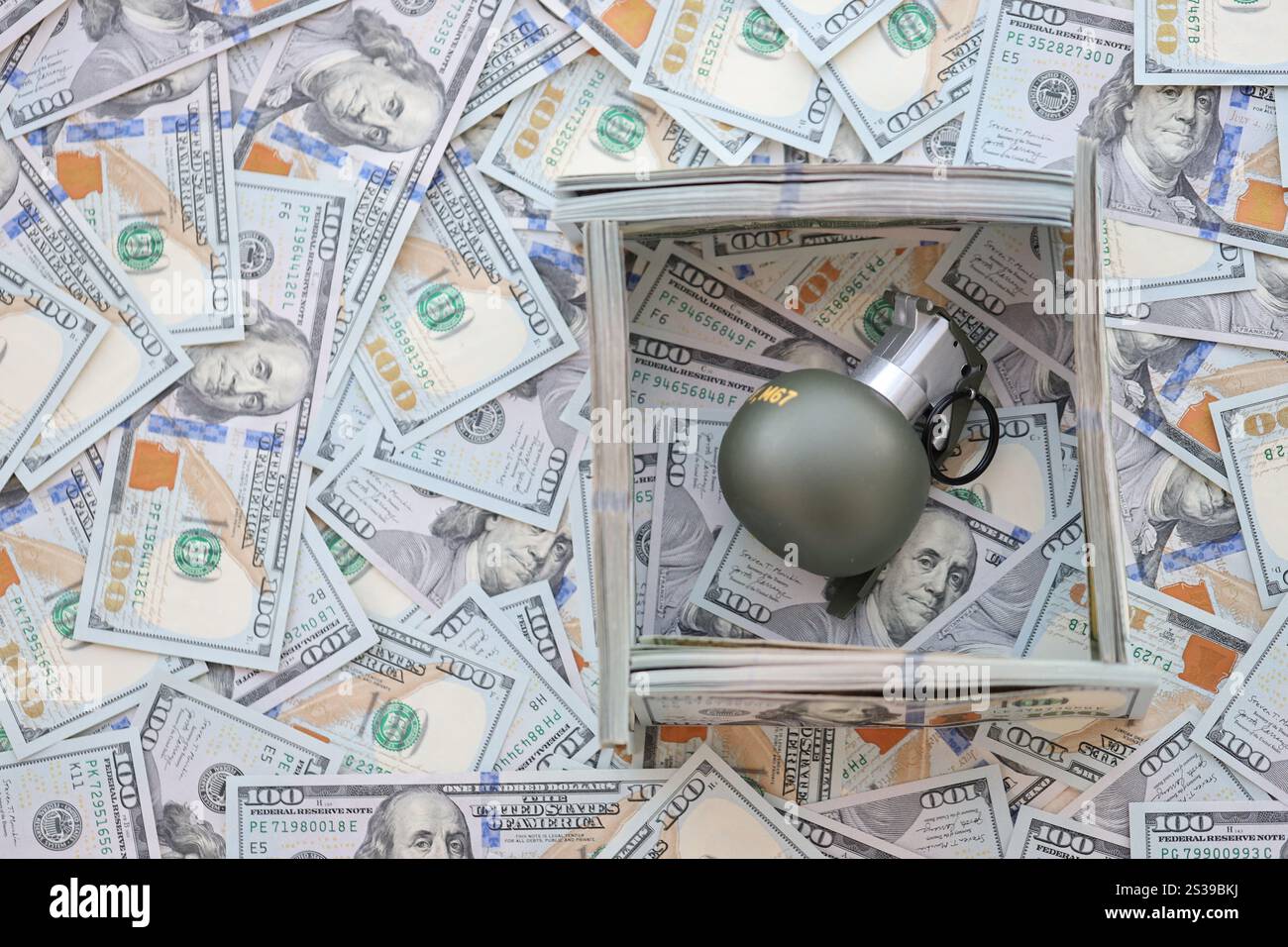 Granate mit einem Scheck vor dem Hintergrund einer riesigen Menge amerikanischer Dollarscheine aus der Nähe. Granate mit einem Scheck vor dem Hintergrund von Riesen Stockfoto