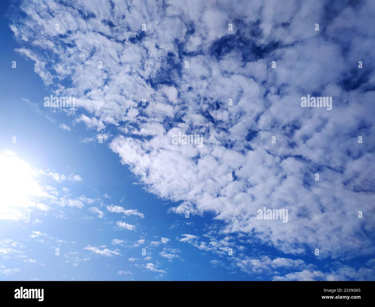 Klare blaue Himmelstruktur und weißer flauschiger Wolkenhintergrund. Die Sonne scheint tagsüber im Sommer hell, Meteorologie. Sanftes Sonnenlicht an Stockfoto