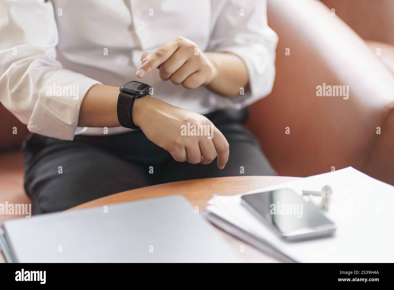 Geschäftsfrau mit Blick auf Smart Watch in der Office Online Connect Gadget-Technologie Stockfoto