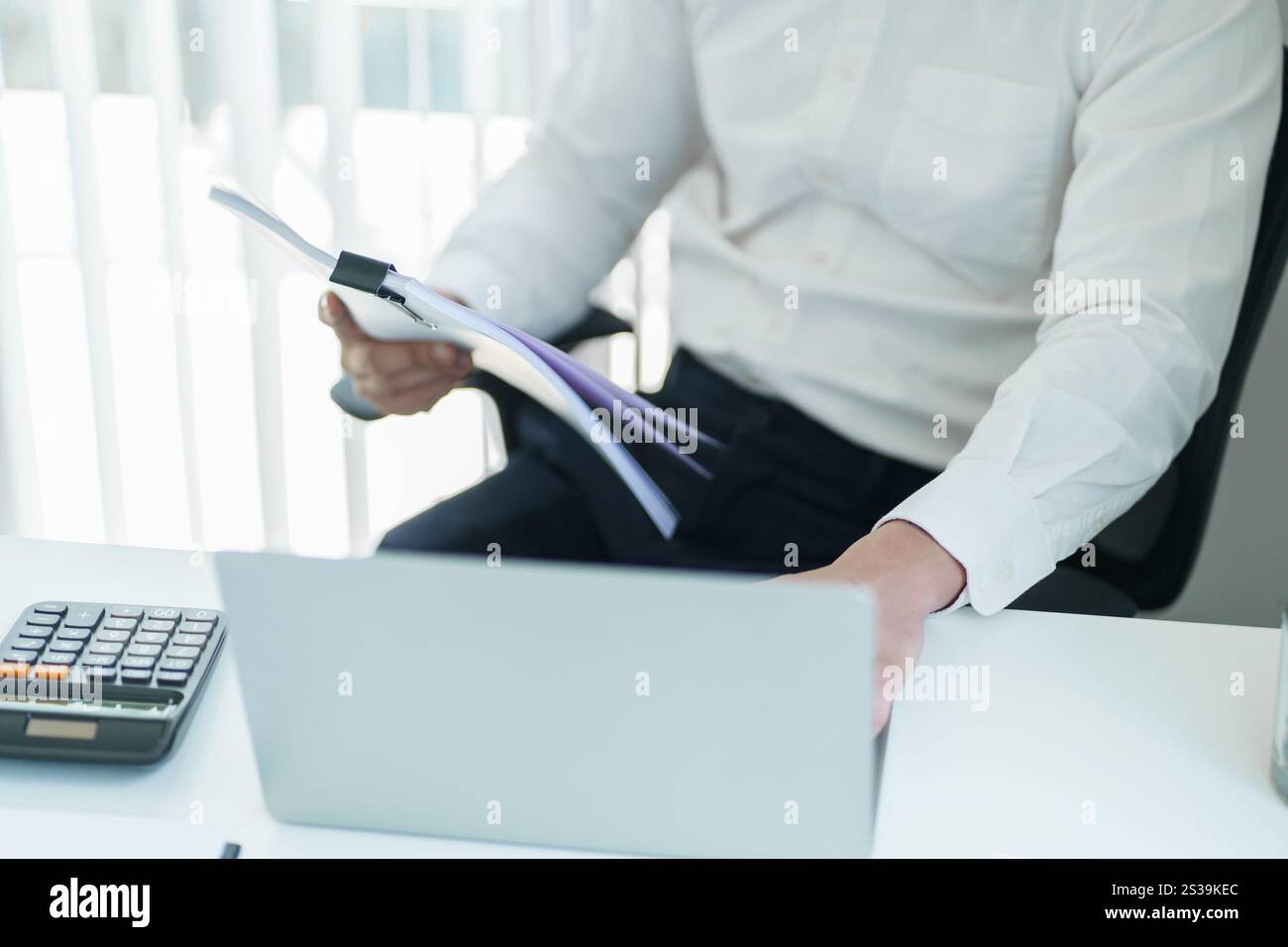 Junger Geschäftsmann, der im Büro arbeitet. Geschäftsmann, der Finanzpapierarbeiten macht, Unternehmensmanagement-Konzept. Stockfoto