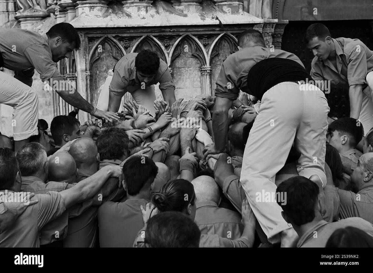 Menschlicher Turm in der Kathedrale von Tarragona, Spanien - Ein spektakuläres Beispiel für die traditionellen „Castells“, die Teamarbeit und das kulturelle Erbe symbolisieren. Stockfoto