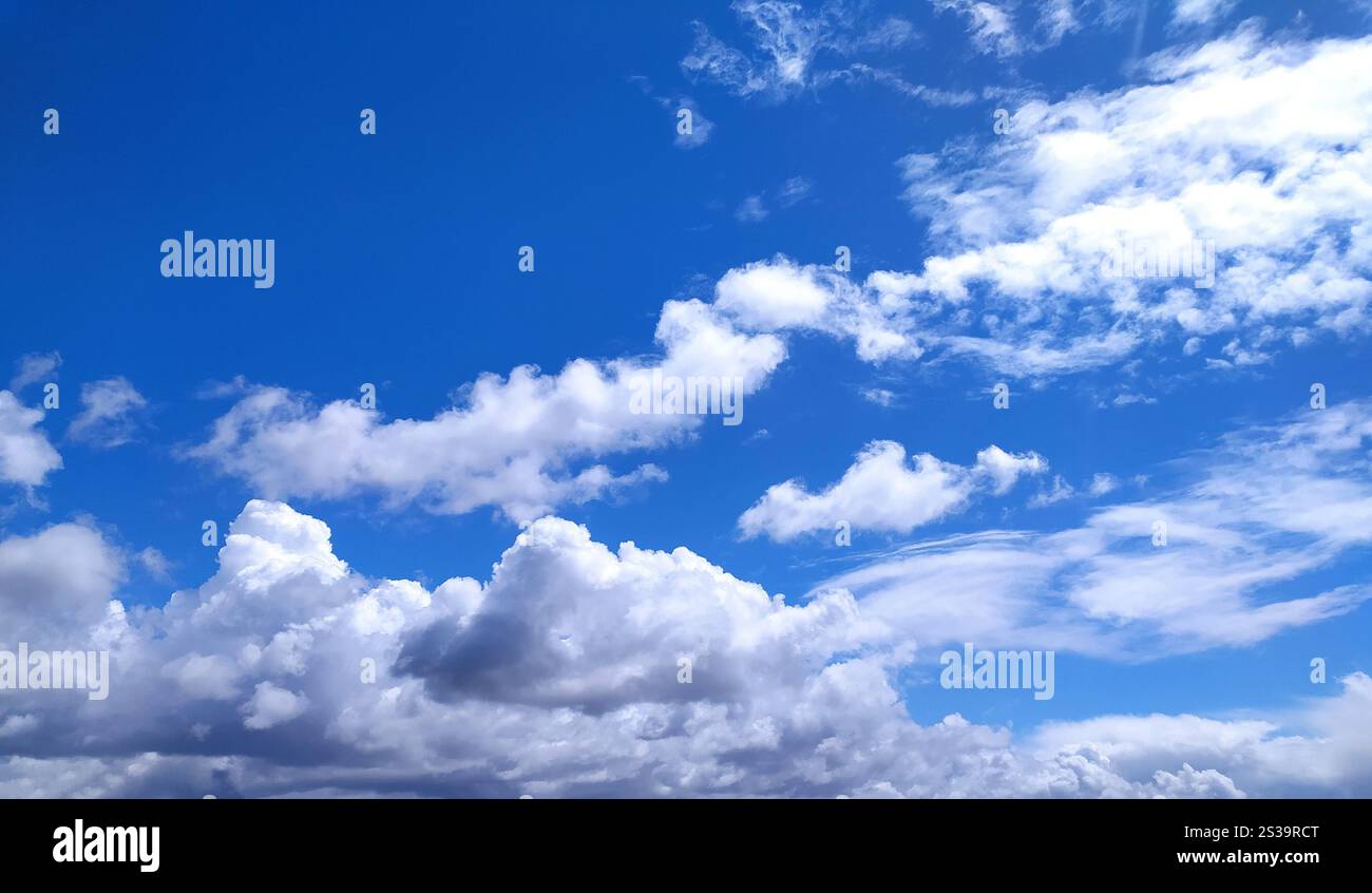 Klare blaue Himmelstruktur und weißer flauschiger Wolkenhintergrund. Die Sonne scheint tagsüber im Sommer hell, Meteorologie. Sanftes Sonnenlicht an Stockfoto