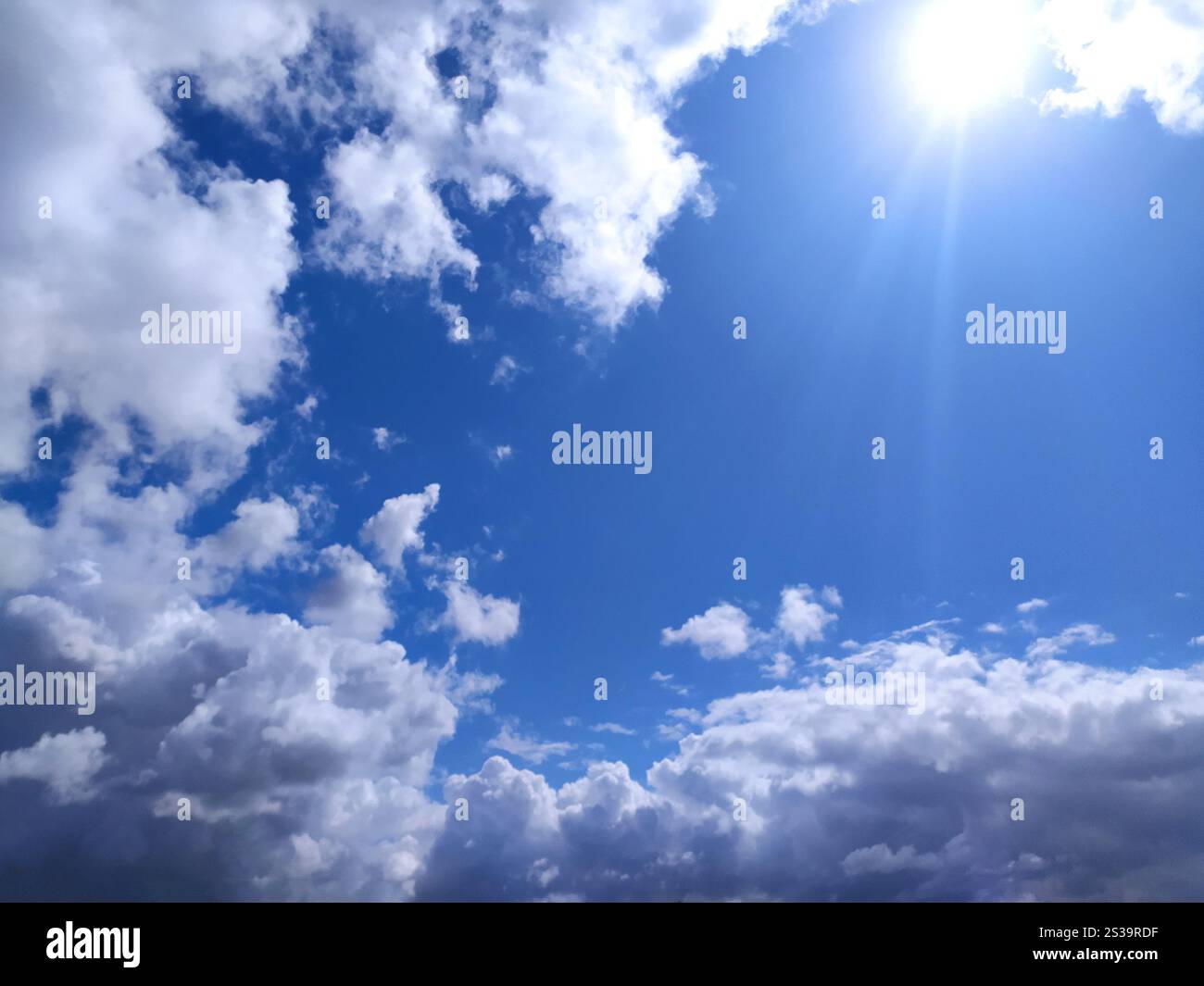 Klare blaue Himmelstruktur und weißer flauschiger Wolkenhintergrund. Die Sonne scheint tagsüber im Sommer hell, Meteorologie. Sanftes Sonnenlicht an Stockfoto