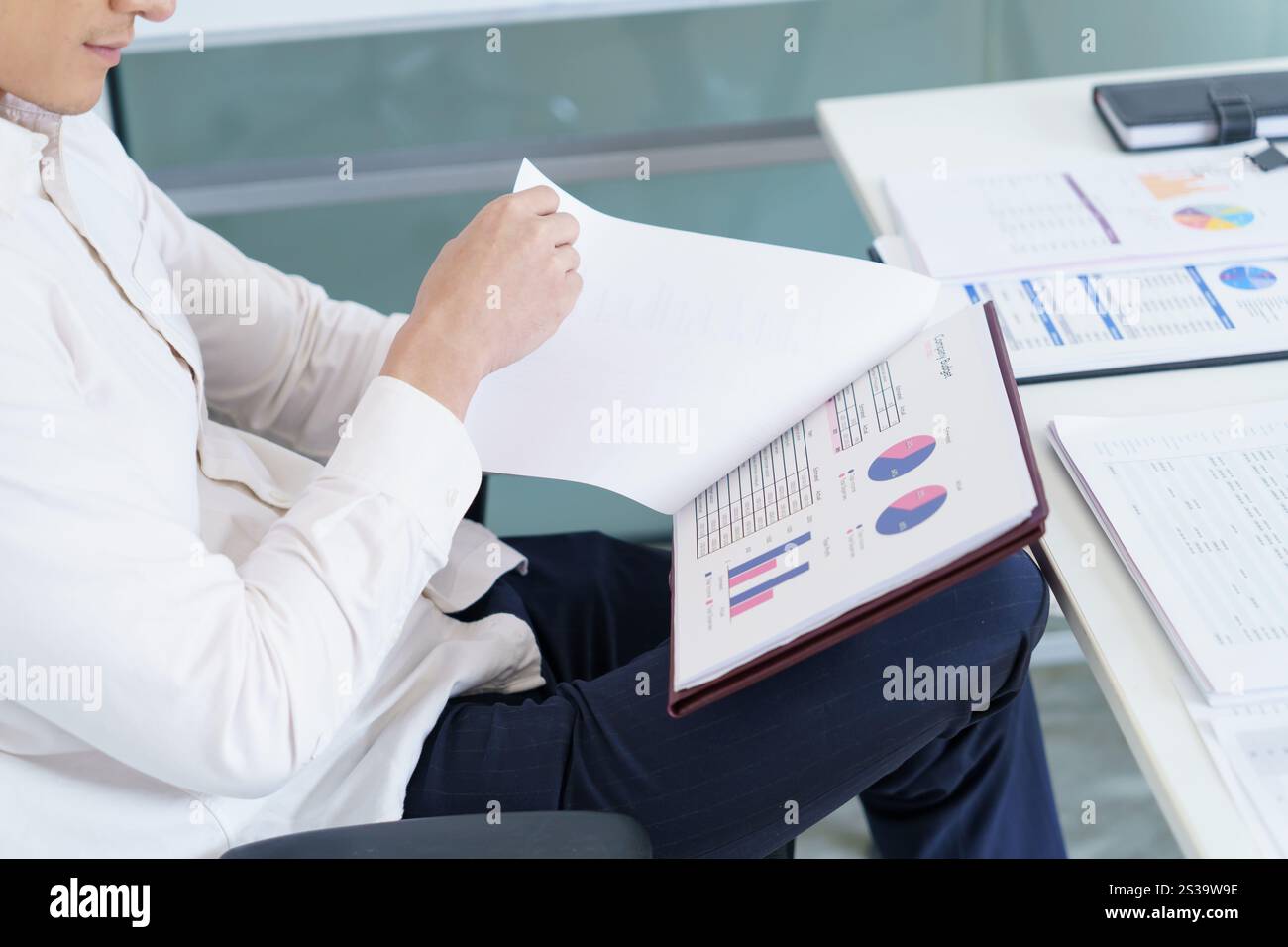 Junger Geschäftsmann, der im Büro arbeitet. Geschäftsmann, der Finanzpapierarbeiten macht, Unternehmensmanagement-Konzept. Stockfoto