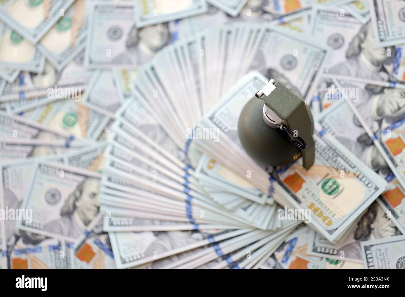 Granate mit einem Scheck vor dem Hintergrund einer riesigen Menge amerikanischer Dollarscheine aus der Nähe. Granate mit einem Scheck vor dem Hintergrund von Riesen Stockfoto