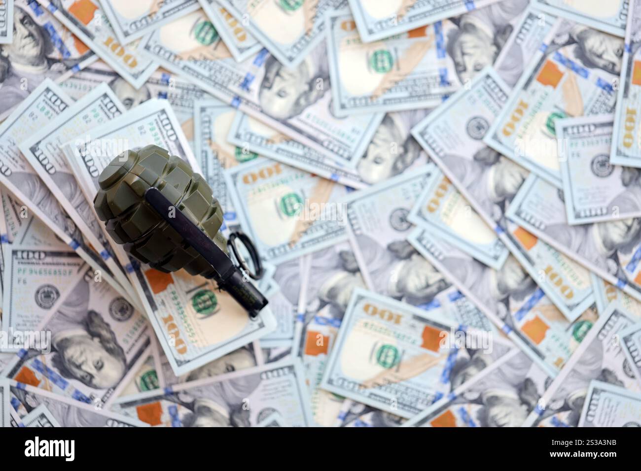 Granate mit einem Scheck vor dem Hintergrund einer riesigen Menge amerikanischer Dollarscheine aus der Nähe. Granate mit einem Scheck vor dem Hintergrund von Riesen Stockfoto