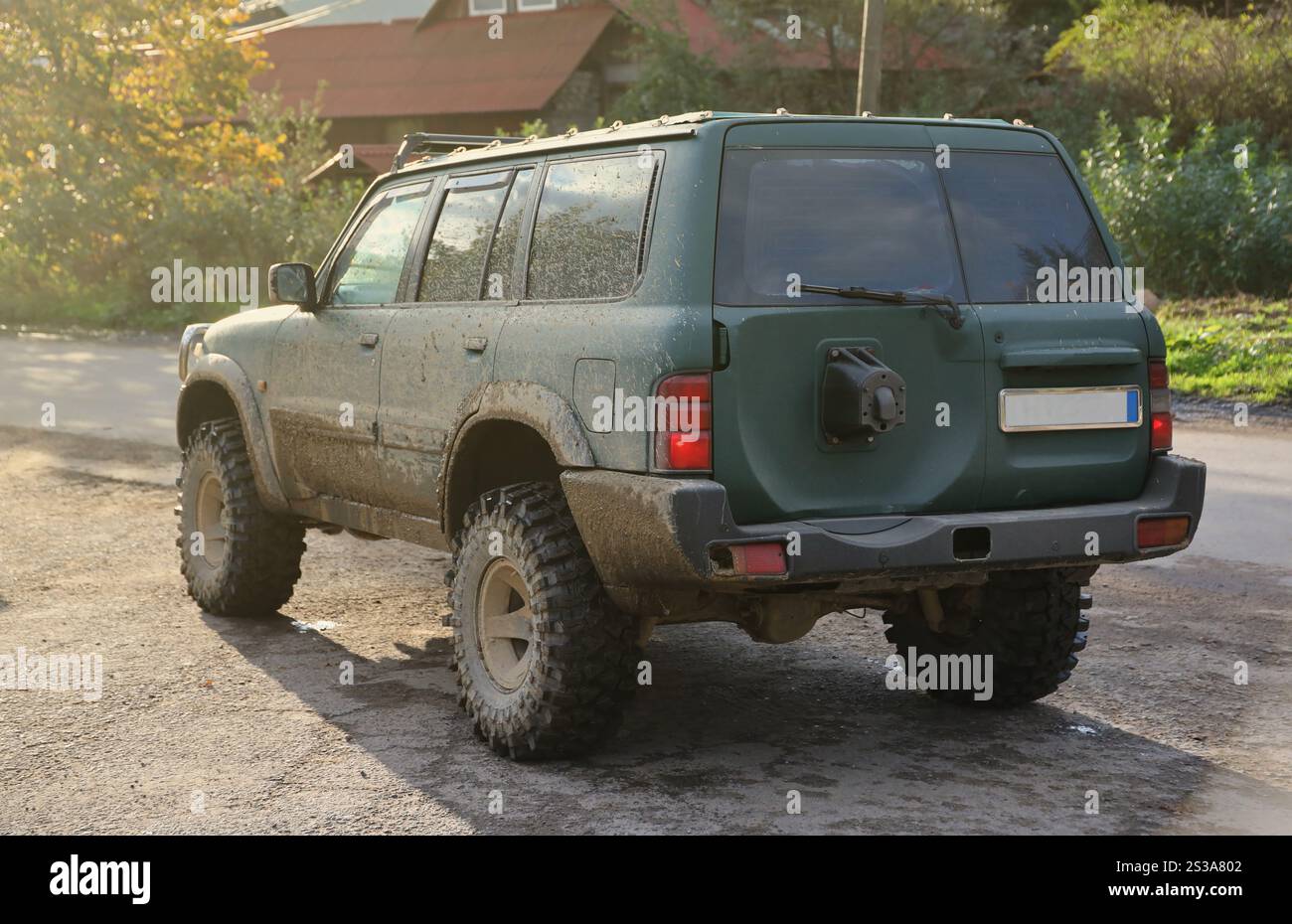 Auto in einer Landschaft mit Schlammweg. Geländewagen mit Geländewagen und Karosserie nach der Fahrt auf schlammigen Straßen. Auto in A Stockfoto