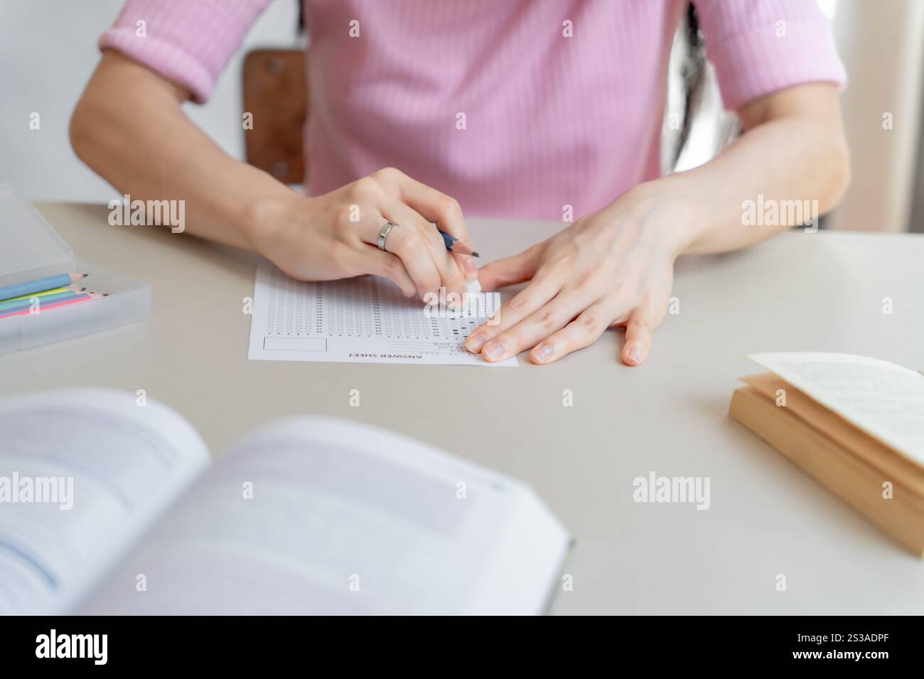 Asiatische Mädchen Studentin, die Prüfung Hand hält Bleistift Schreiben Antwort in der Universität Klassenbildung High School oder Universitätsstudentin macht Notizen Stockfoto