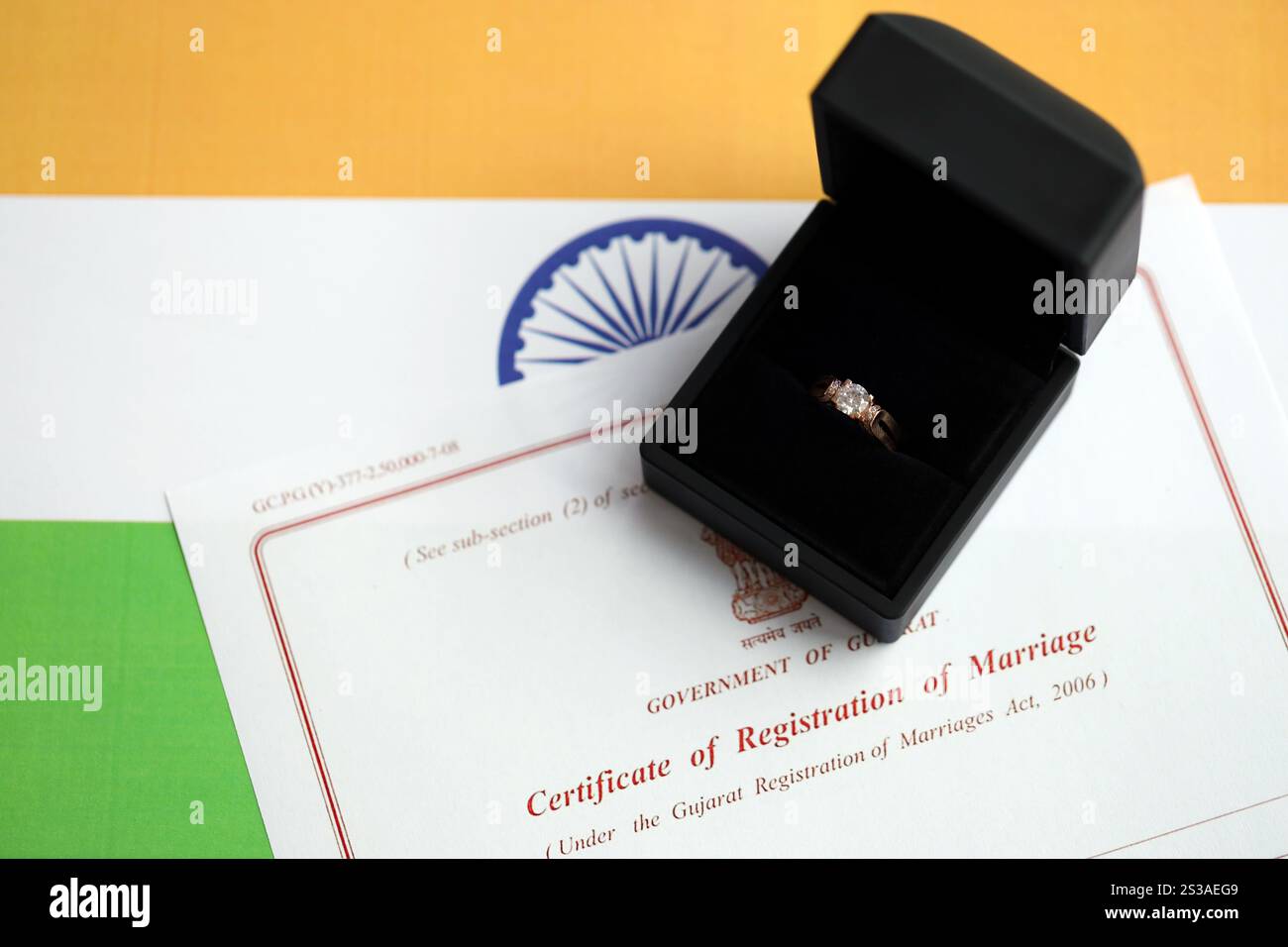 Indische Bescheinigung über die Registrierung der Ehe Blankodokument und Ehering auf Fahne Nahaufnahme. Indische Bescheinigung über die Registrierung der Ehe leer Stockfoto