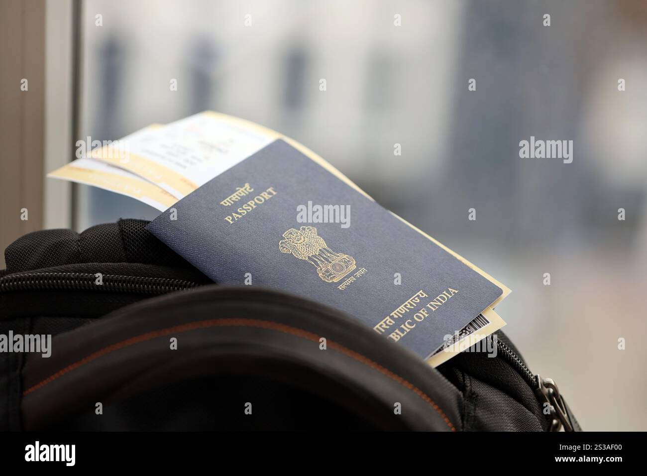 Blauer indischer Pass mit Flugtickets auf touristischem Rucksack aus nächster Nähe. Tourismus und Reisekonzept Stockfoto