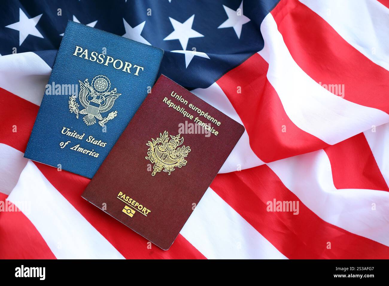 Pass von Frankreich mit US Pass auf Vereinigte Staaten von Amerika gefaltete Flagge aus nächster Nähe. Pass von Frankreich mit US-Pass für die Vereinigten Staaten von Amerika Stockfoto