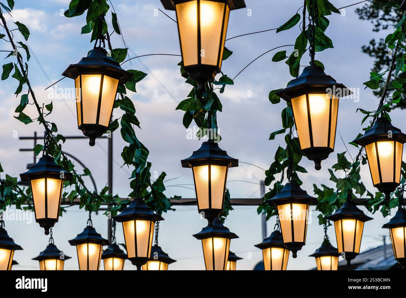 Viele elektrische Straßenlaternen unter dunkelblauem bewölktem Himmel in der Sommerdämmerung in Gyumri Stadt, Armenien am Abend Stockfoto