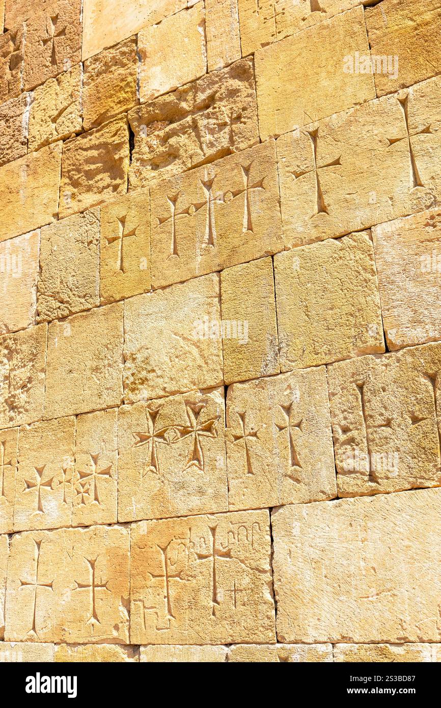 Gelbe Wand der Kirche mit alten geschnitzten Kreuzen im Noravank-Kloster in den Provinzen Vayots Dzor, Armenien an sonnigen Sommertagen Stockfoto