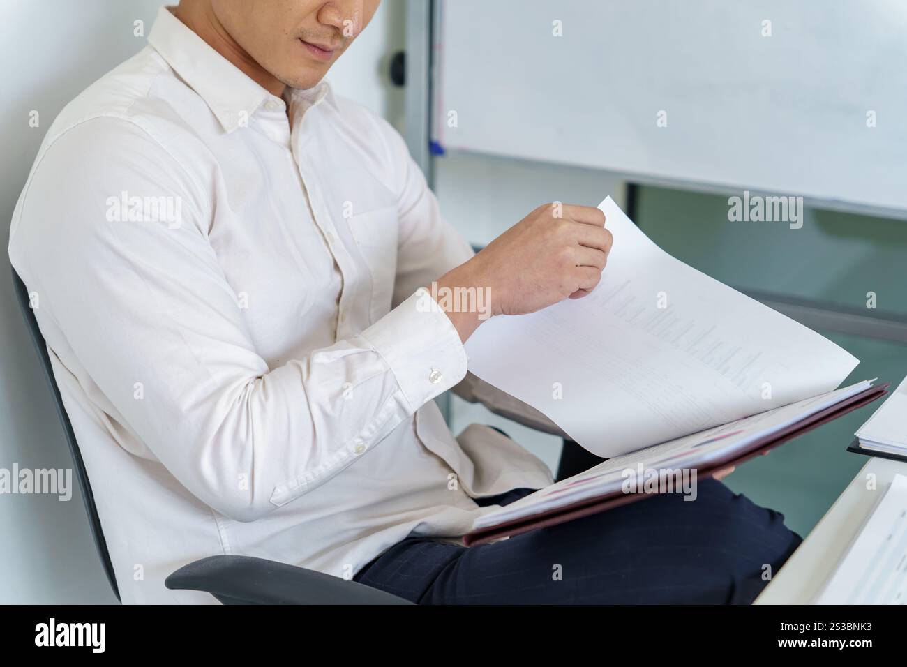 Junger Geschäftsmann, der im Büro arbeitet. Geschäftsmann, der Finanzpapierarbeiten macht, Unternehmensmanagement-Konzept. Stockfoto