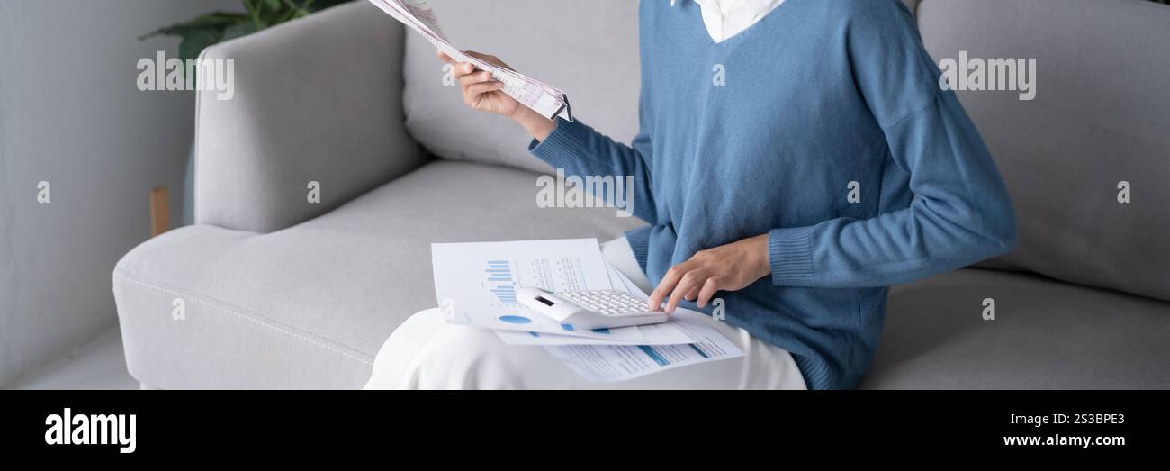 Asiatische Frau, die Papierdokumente hält, berechnet Geldeinsparungen Bezahlen von Rechnungen in mobiler Anwendung mit Smartphone-Zahlung online mit Bezahlen Stockfoto