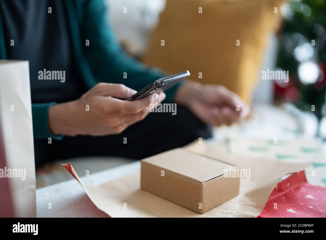 Mann im Pullover Verpackung weihnachtsgeschenke mit Öko Papier Mädchen Verpackung weihnachtsgeschenke weihnachten weihnachtskonzept. Stockfoto
