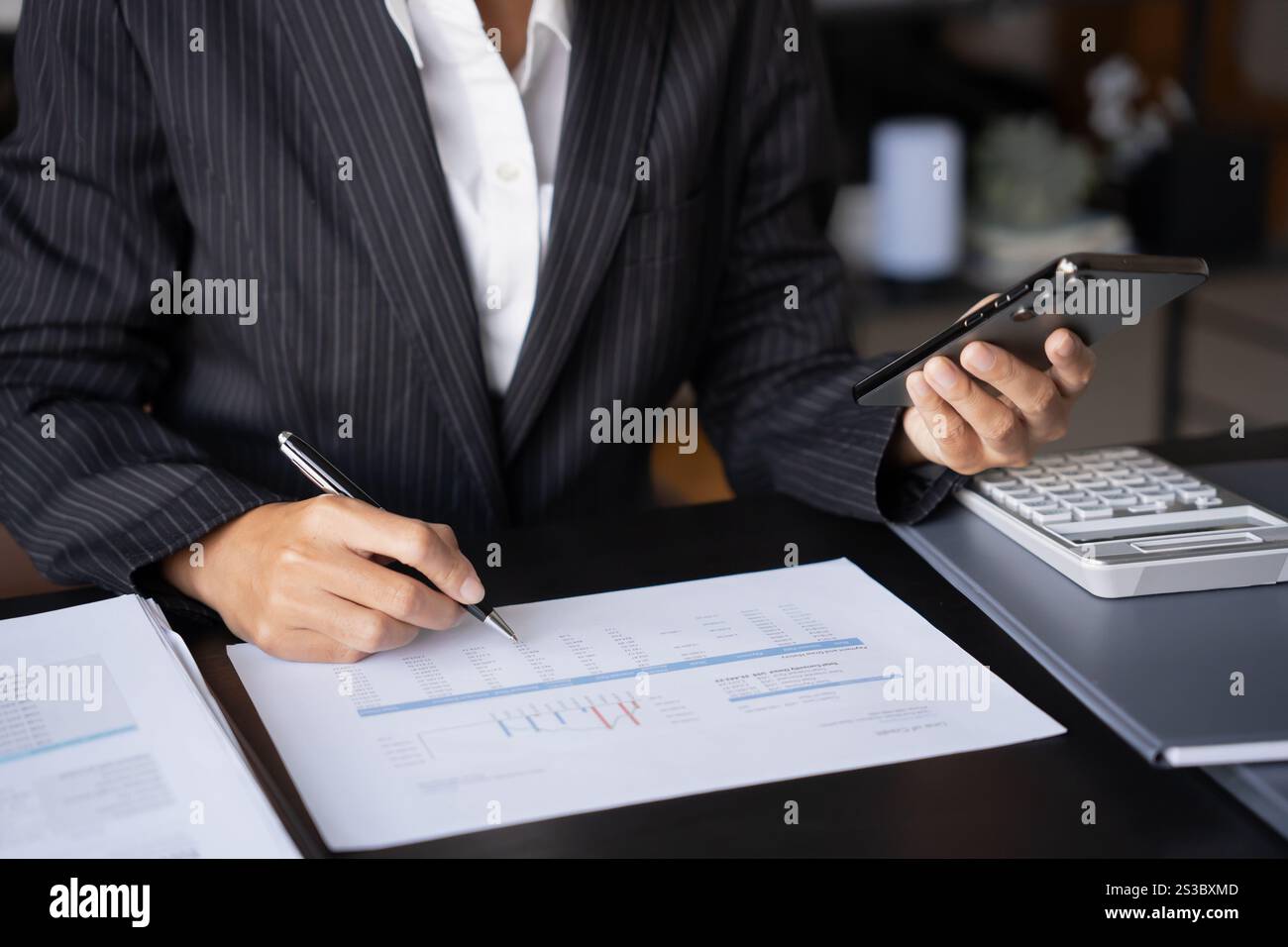 Asiatische Geschäftsfrau, die ihr Smartphone benutzt und Zeit damit verbringt, Nachrichten in sozialen Medien zu lesen. Stockfoto