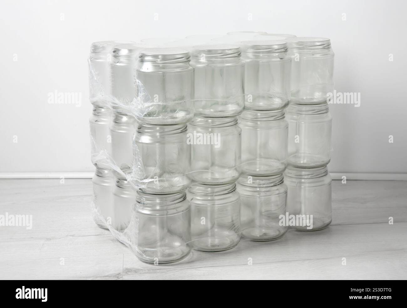 Ein Stapel leerer, sauberer Glasgläser übereinander. Im Zimmer, weißer Hintergrund. Stockfoto