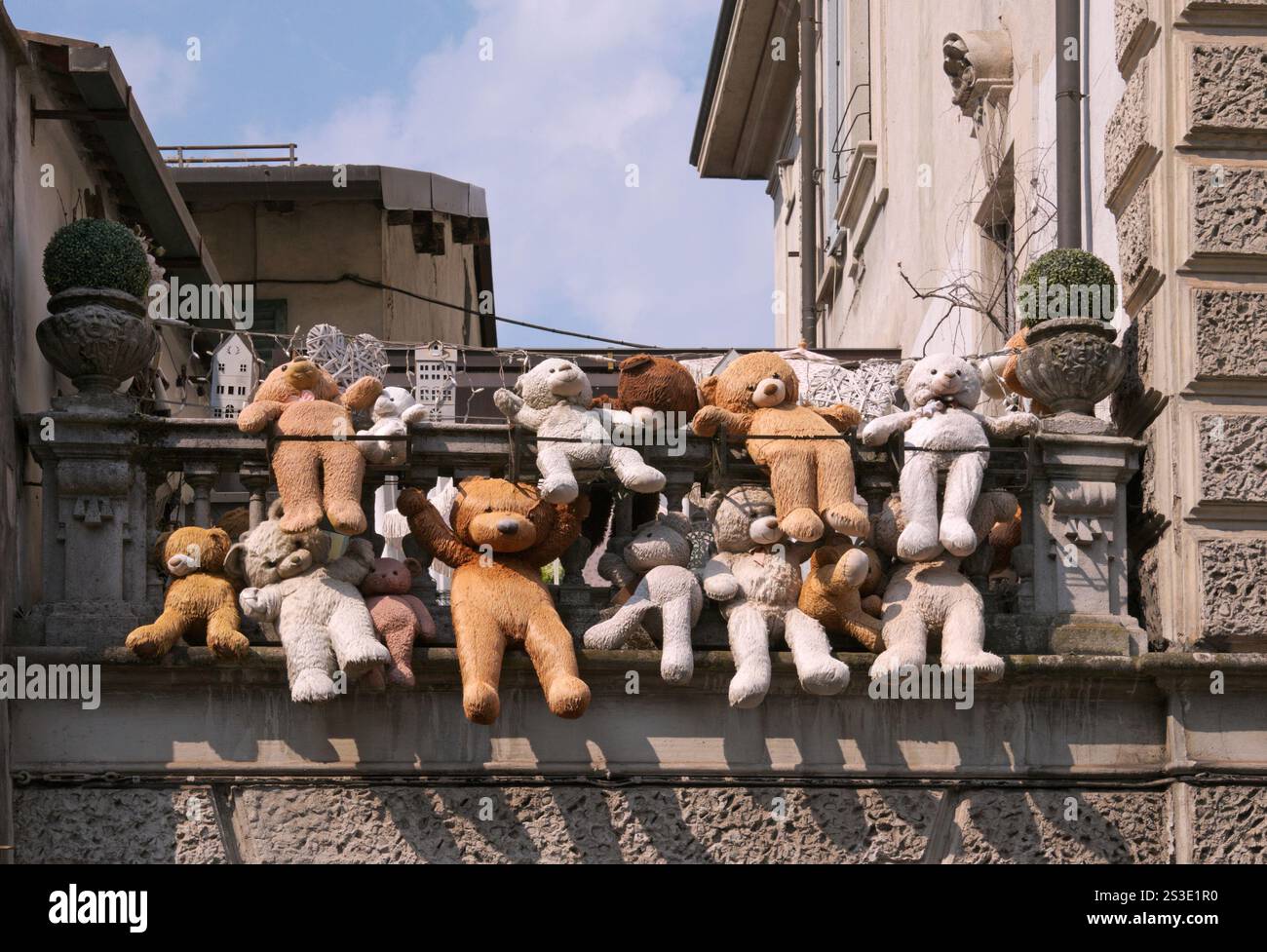 Verschiedene Teddybären hängen auf dem Balkon Stockfoto
