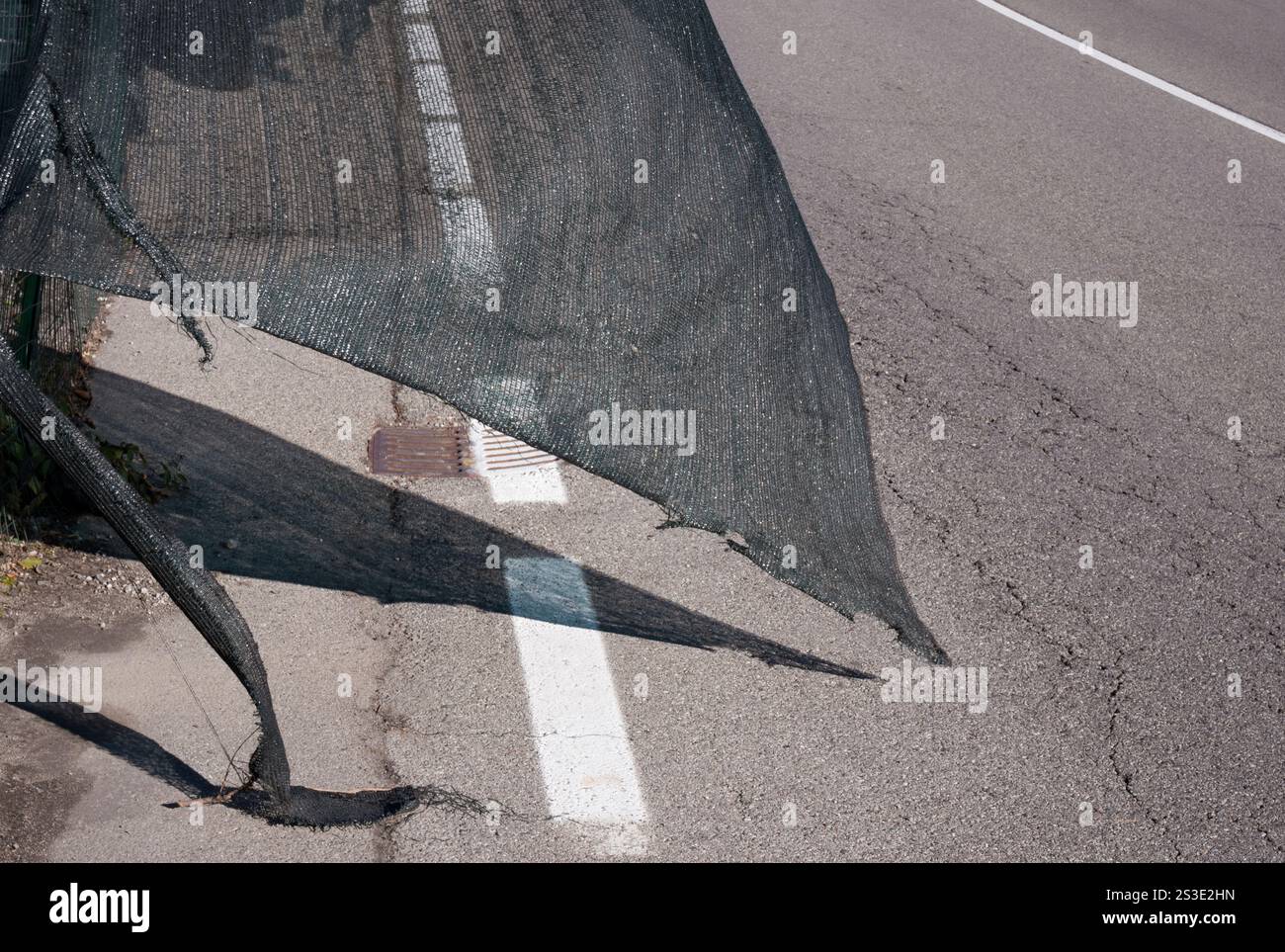 Zerrissenes Zaunnetz auf der Baustelle, das im Wind am Straßenrand weht Stockfoto