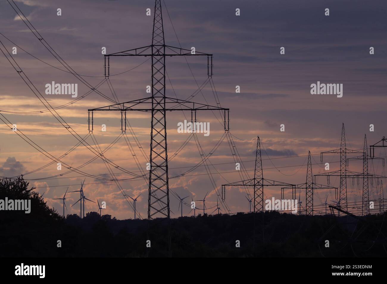 01.07.2024, Greifswald, Mecklenburg-Vorpommern, GER - Silhouetten von Strommasten und Windraedern. Aussen, Aussenaufnahme, Daemmerung, deutsch, Deutschland, Elektrizitaet, Elektrosmog, Energie, Energiebedarf, Energien, Energiepolitik, Energietransport, Energieverbrauch, Energieversorgung, Energiewirtschaft, Europa, europaeisch, Greifswald, Hochspannung, Hochspannungsleitungen, Hochspannungsmasten, Jahreszeit, Kabel, Leitungen, Masten, Mecklenburg-Vorpommern, niemand, QF, Querformat, Schattenrisse, Silhouetten, Strom, Strombedarf, Stromkabel, Stromleitungen, Strommasten, Stromversorgung, Techni Stockfoto