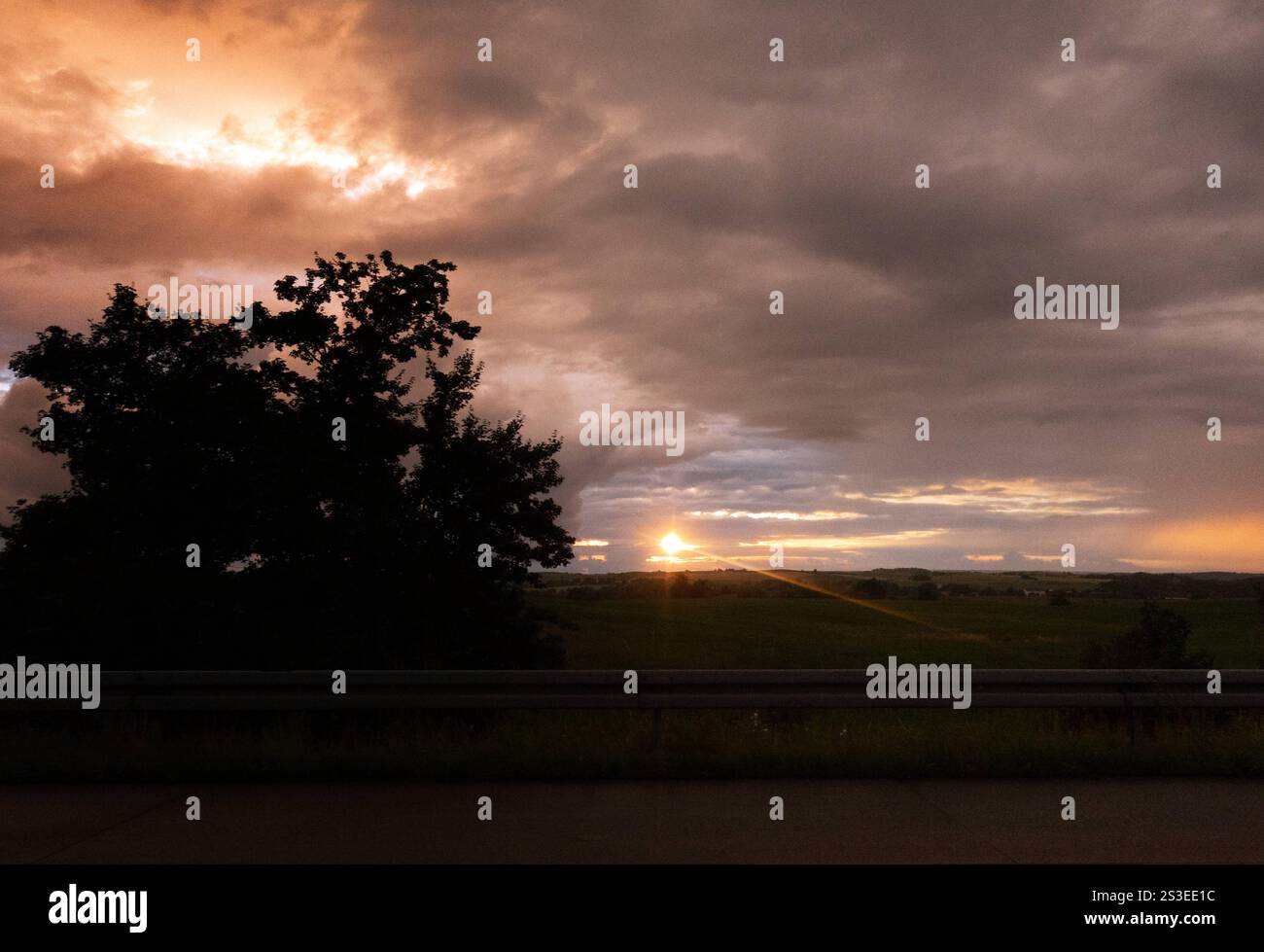 01.07.2024, Greifswald, Mecklenburg-Vorpommern, GER - Dramatischer Wolkenhimmel bei Sonnenuntergang. Abend, Abenddämmerung, Abendhimmel, Abendlicht, Abendroete, Abends, Abendstimmung, Aussen, Aussenaufnahme, Baeume, bewoelkt, Daemmerung, deutsch, Deutschland, dramatisch, einsam, Einsamkeit, Europa, europaeisch, Gegenlicht, Gegenlichtaufnahme, Gewitterwetter, Gewitterwolken, Greifswald, Himmel, Himmelskoerper, Horizont, Idylle, idyllisch, Jahreszeit, Landschaft, Landschaftsaufnahme, Lichtstimmung, Mecklenburg-Vorpommern, Meteorologie, Natur, Naturschauspiel, niemand, QF, Querformat, Ruhe, ruhi Stockfoto