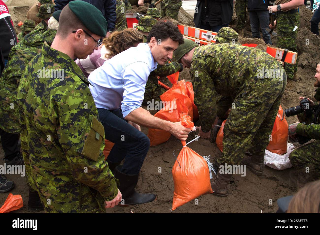Premierminister Justin Trudeau und Kanadische Streitkräfte arbeiten bei der Hochwasserhilfe zusammen und füllen Sandsäcke zum Schutz der Gemeinde Stockfoto