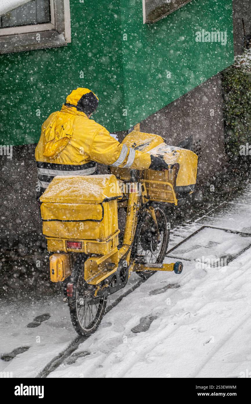 Winterwetter, starker Schneefall, Innenstadtverkehr, Postbote mit Fahrrad im Schneetreiben, Essen, NRW, Deutschland Winterwetter *** Winterwetter, starker Schneefall, Innenstadtverkehr, Briefträger mit Fahrrad im Schnee, Essen, NRW, Deutschland Winterwetter Stockfoto